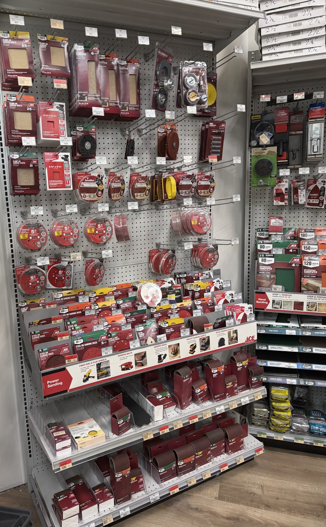 Ace Hardware brand sanding belts, sanding discs, and sandpaper sheets displayed on an endcap display at Hessler Paint & Hardware in Delray Beach, Florida.