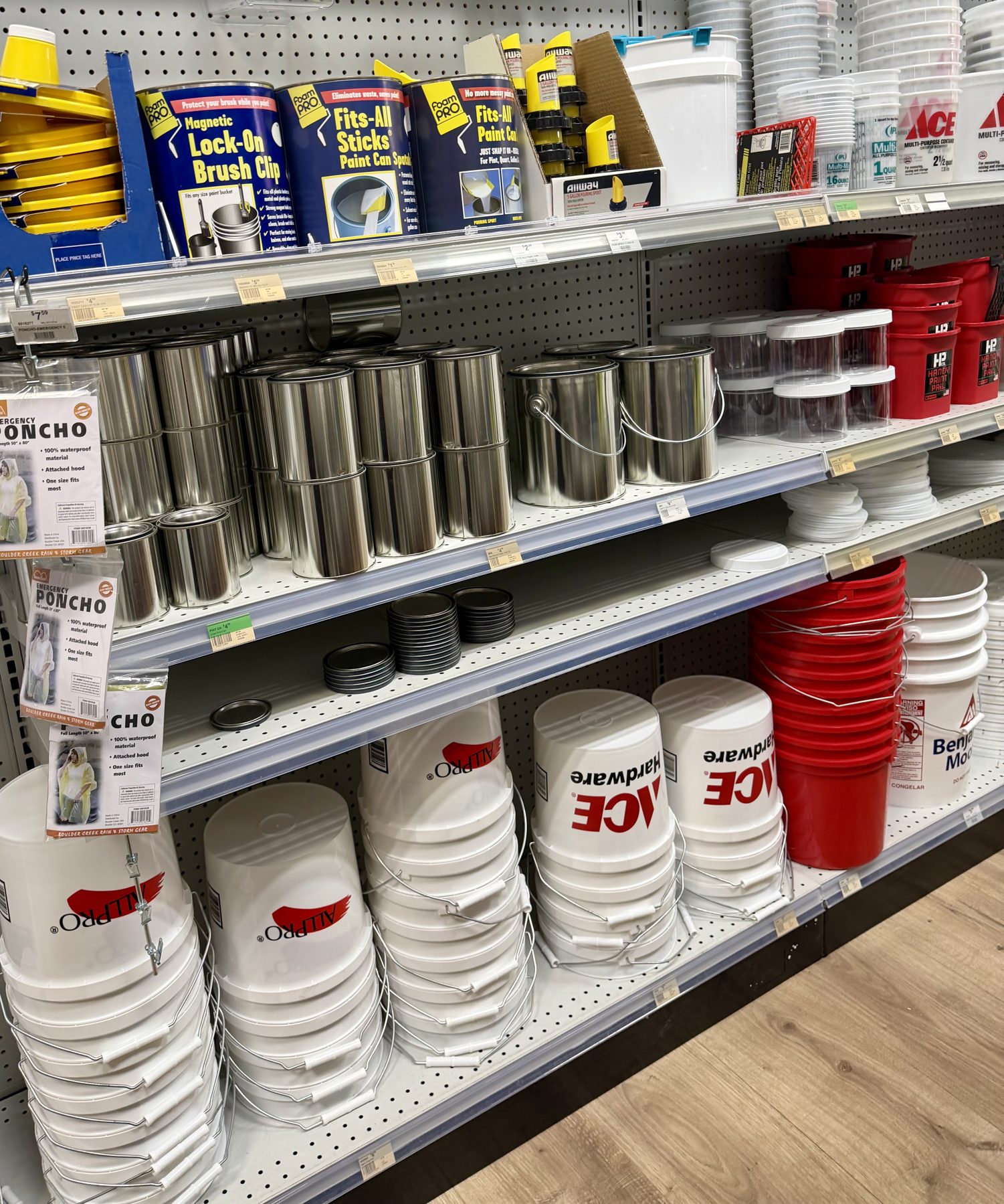 Shelves stocked with empty metal paint cans, FoamPro paint accessories, Allpro pails, and Ace Hardware buckets at Hessler Paint & Hardware in Delray Beach, Florida.