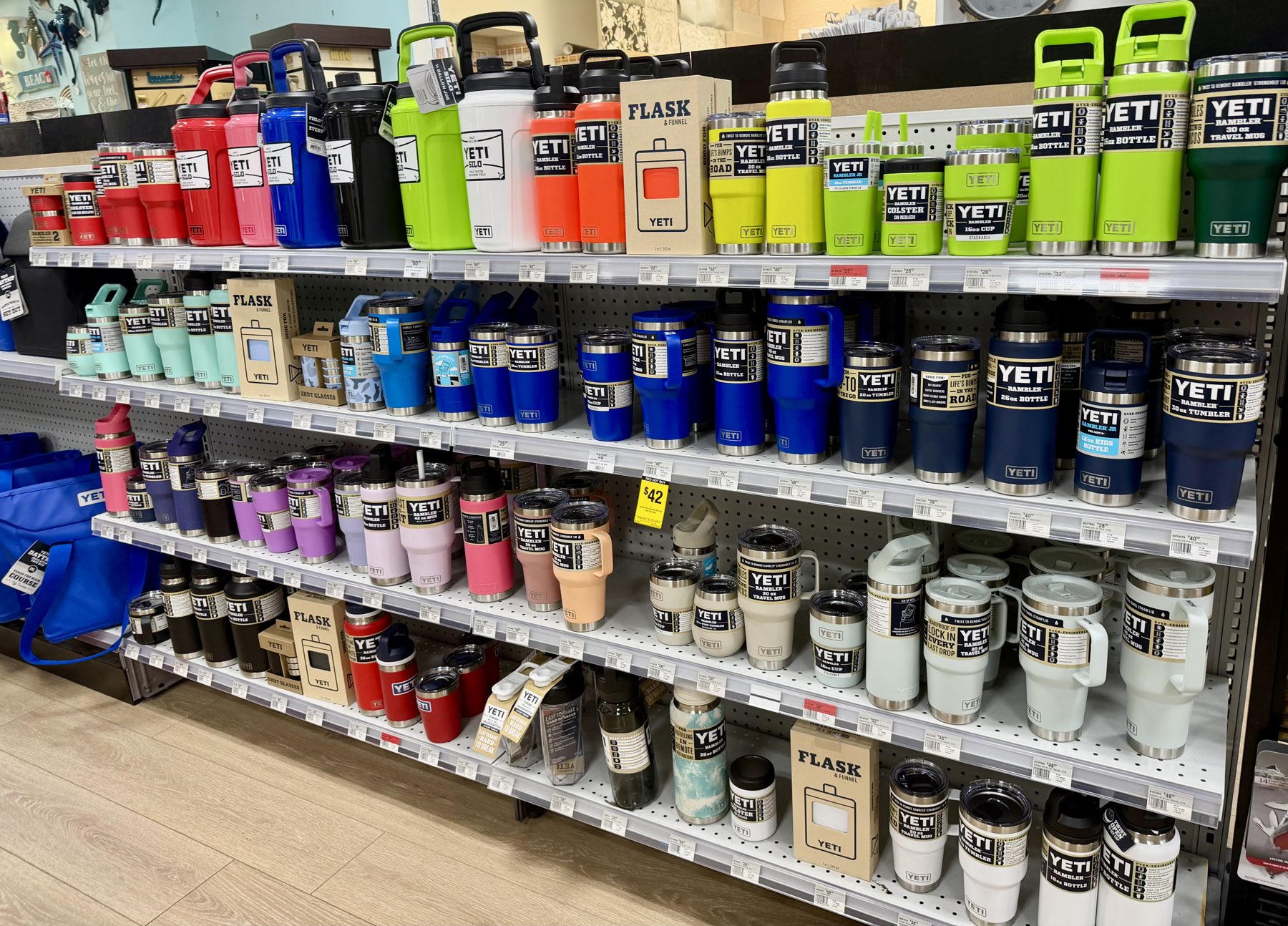 Display shelves loaded with colorful YETI Rambler tumblers, water bottles, travel mugs, and flasks at Hessler Paint & Hardware in Delray Beach, Florida.