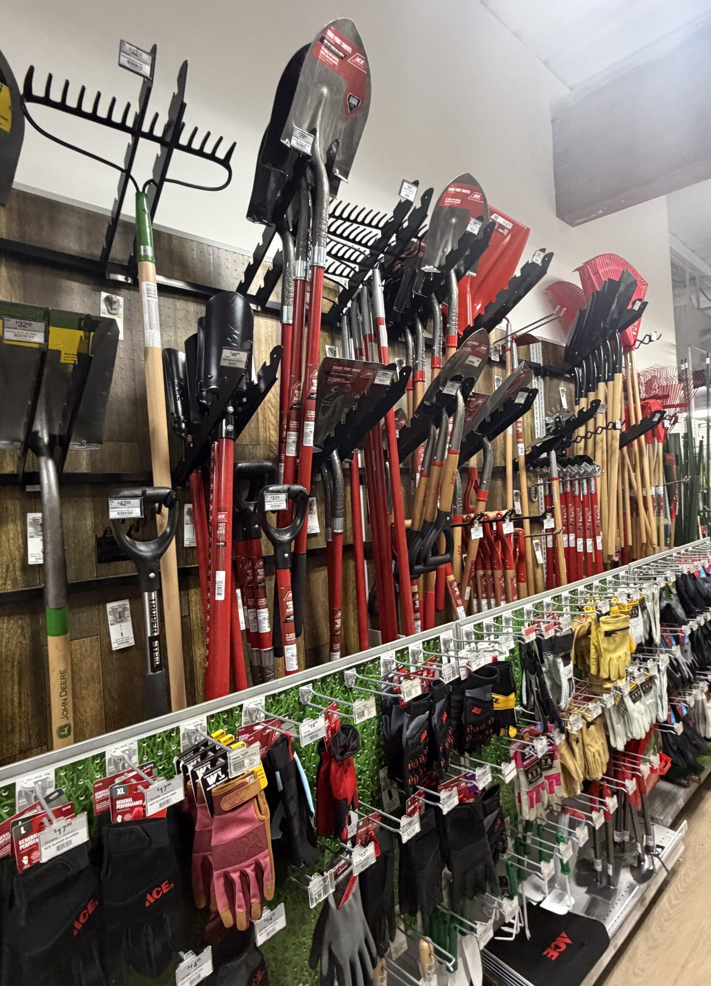 A display of Ace brand garden gloves, shovels, and rakes including John Deere tools at Hessler Paint & Hardware in Delray Beach, Florida.