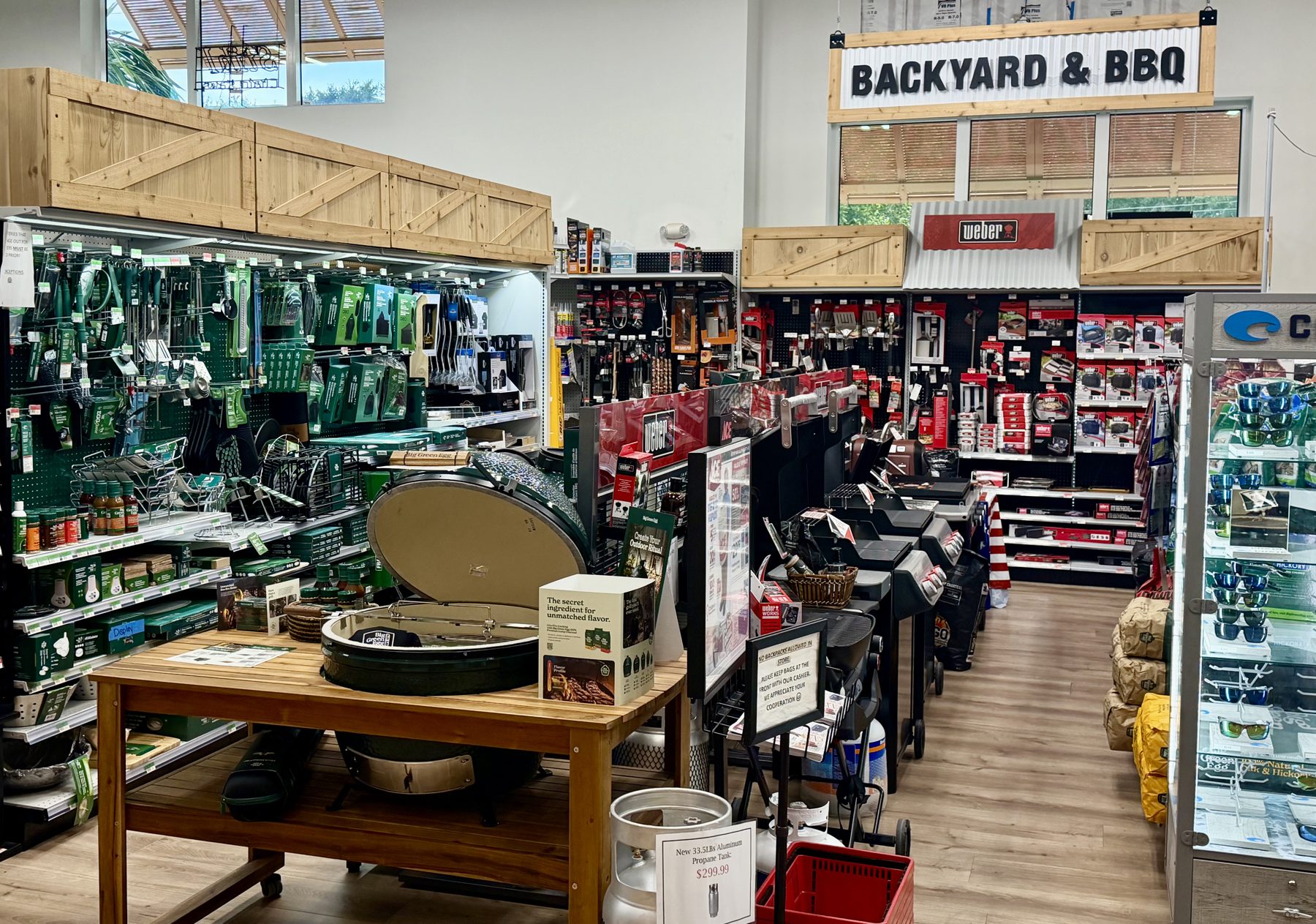 Big Green Egg ceramic grill and accessories displayed alongside Weber gas grills in the Backyard and BBQ department at Hessler Paint & Hardware in Delray Beach, Florida.