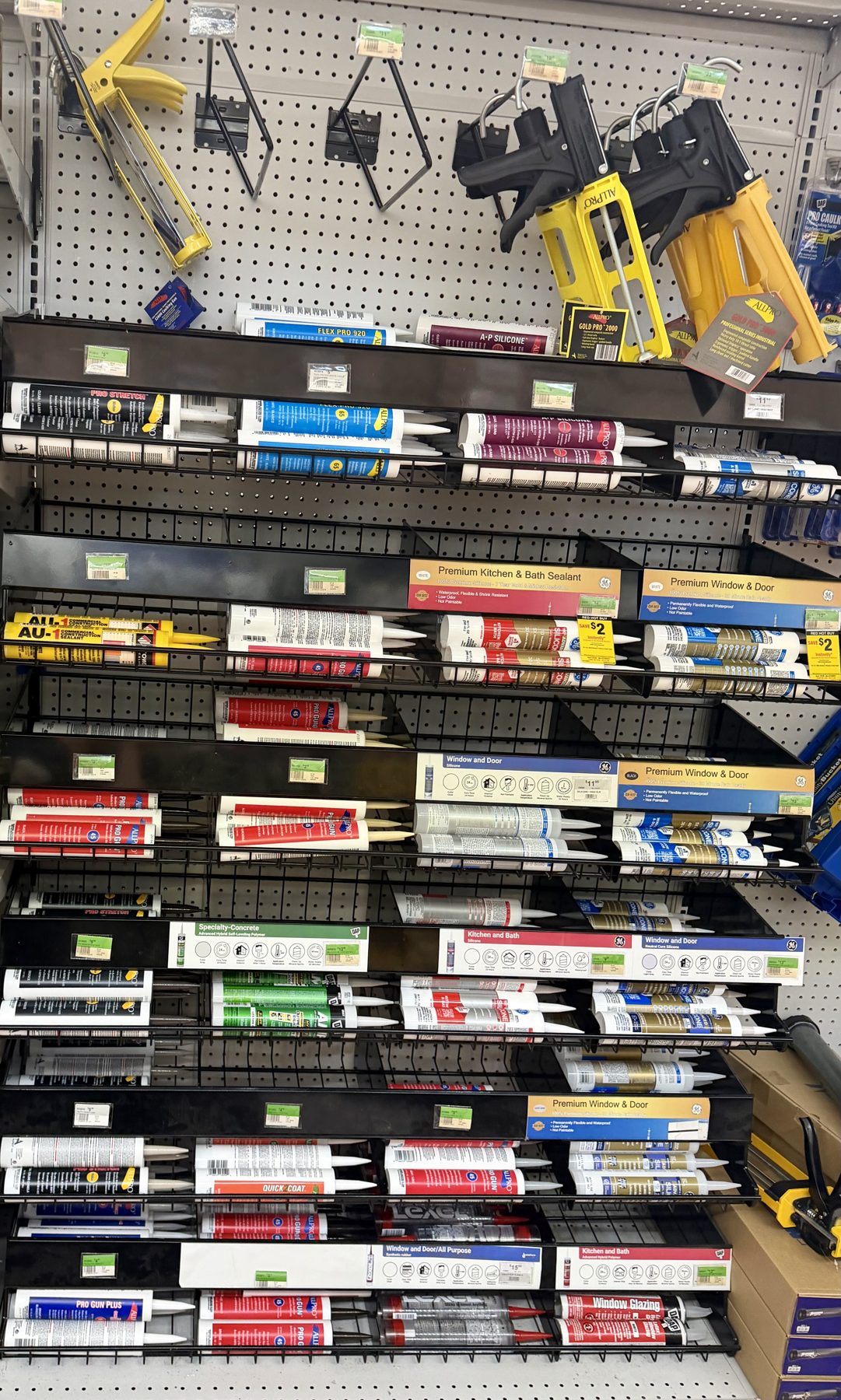 Display of caulking guns, caulk tubes, silicone, kitchen and bath sealants, and window and door sealants at Hessler Paint & Hardware in Delray Beach, Florida.