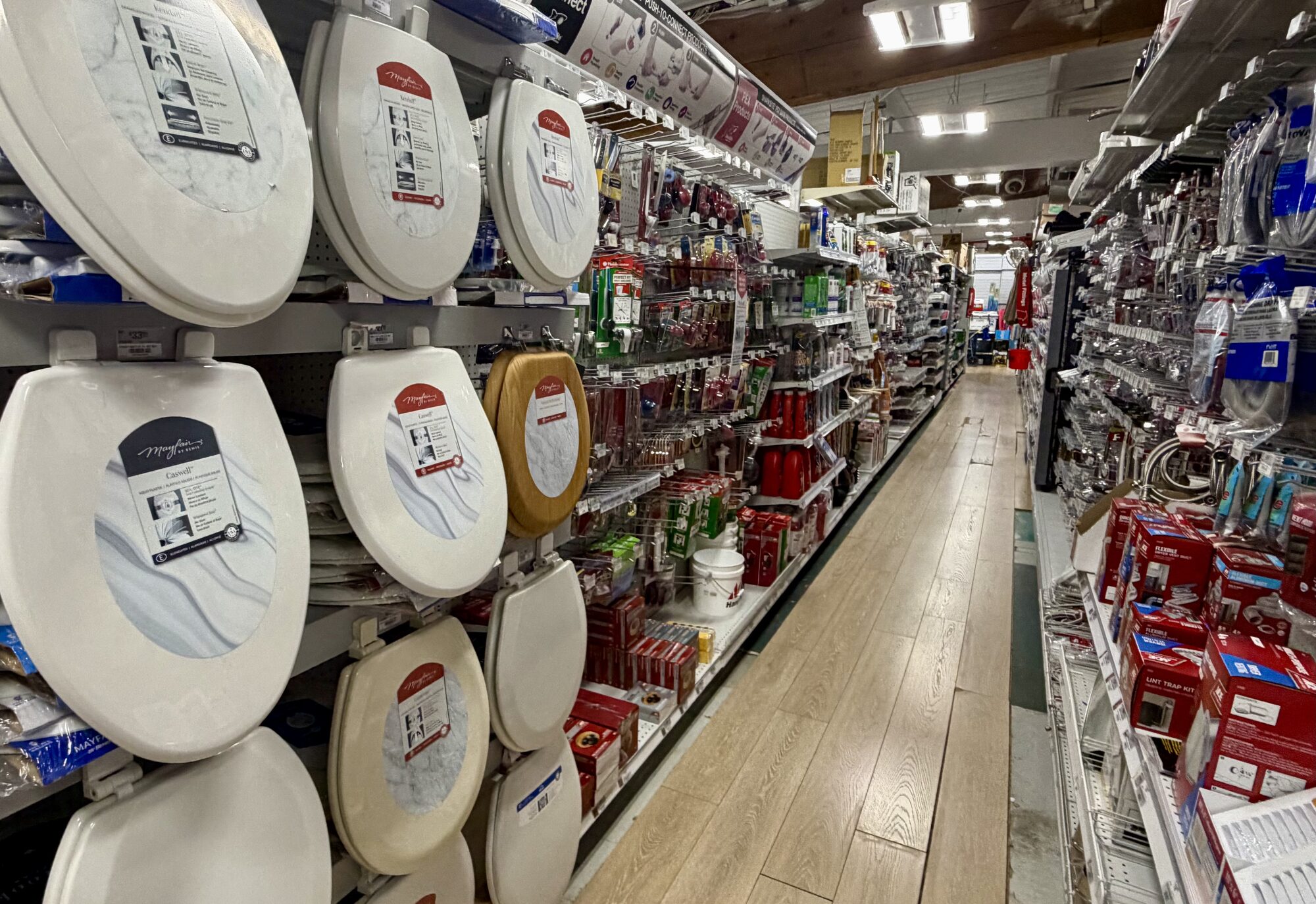 A wide variety of Mayfair toilet seats and plumbing supplies on display at Hessler Paint & Hardware in Delray Beach, Florida.