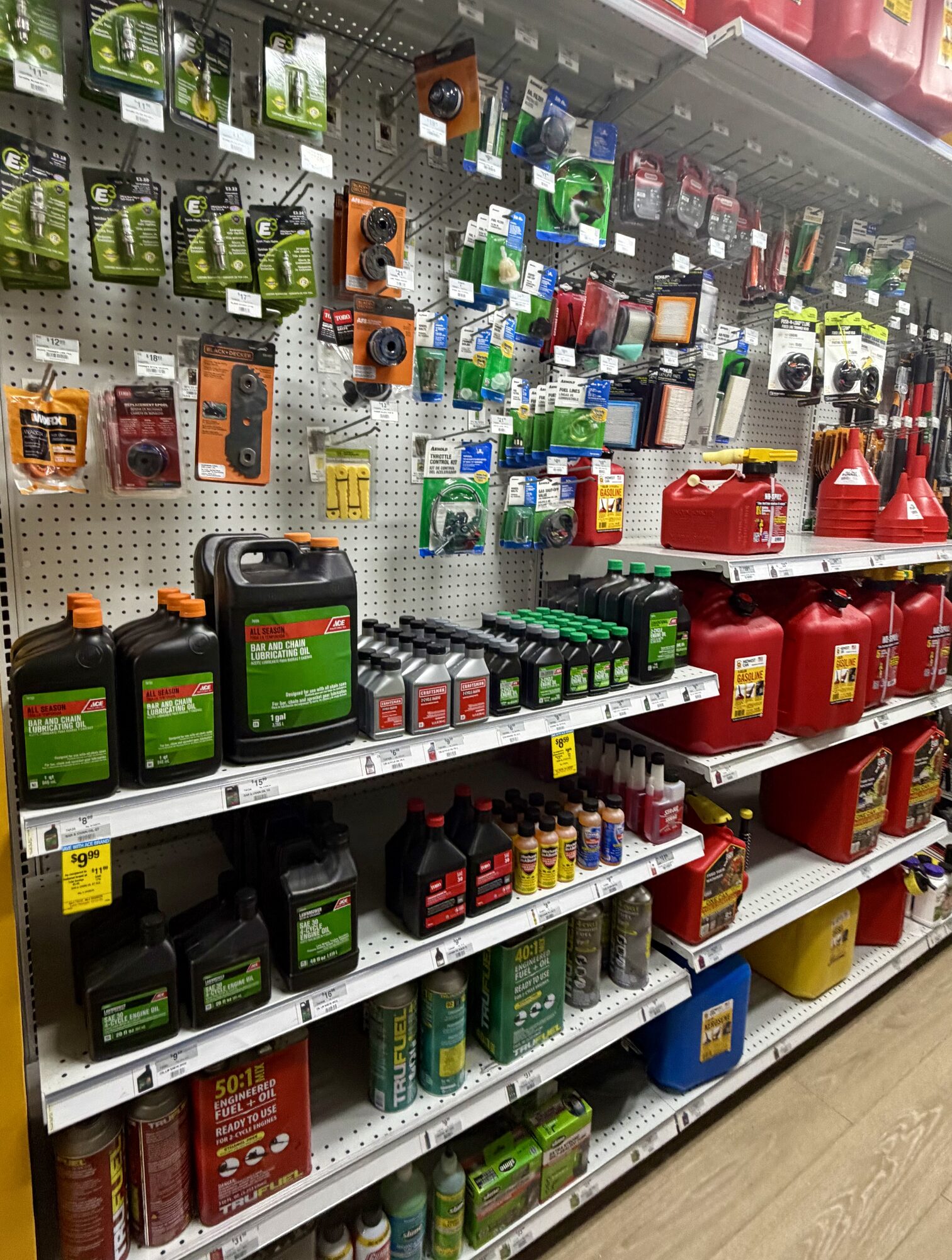 Shelves of TruFuel, E3 spark plugs, bar and chain oil, and red gas cans at Hessler Paint & Hardware in Delray Beach, Florida.