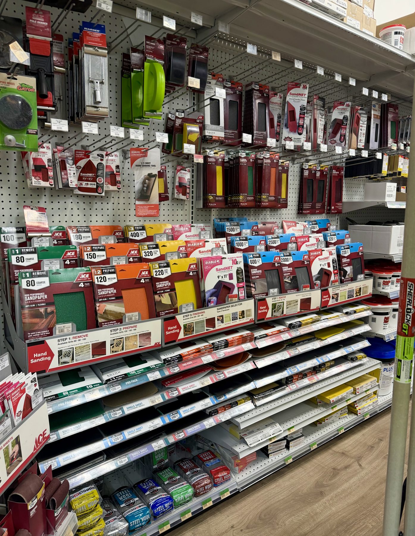 Aisle display stocked with Ace sandpaper sheets, Diablo SandNet abrasives, hand sanding blocks, and steel wool packs at Hessler Paint & Hardware in Delray Beach, Florida.