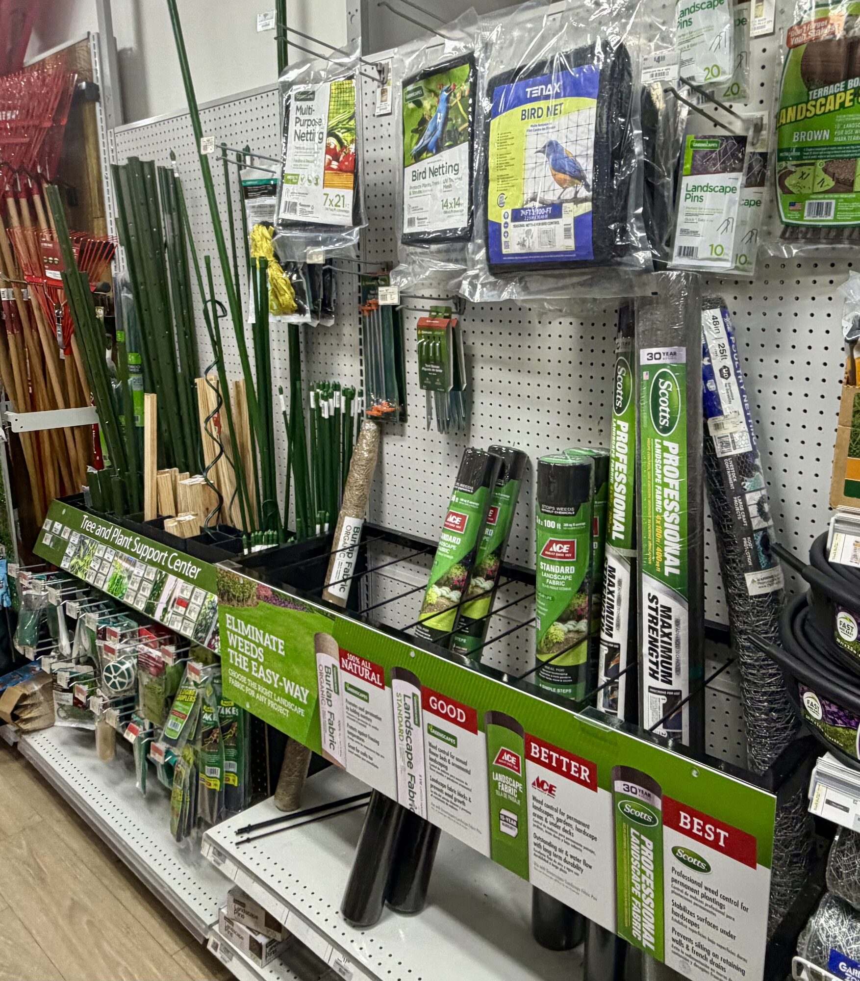 A display of Ace landscape fabric, Scotts professional landscape fabric, Tenax bird netting, and garden stakes at Hessler Paint & Hardware in Delray Beach, Florida.