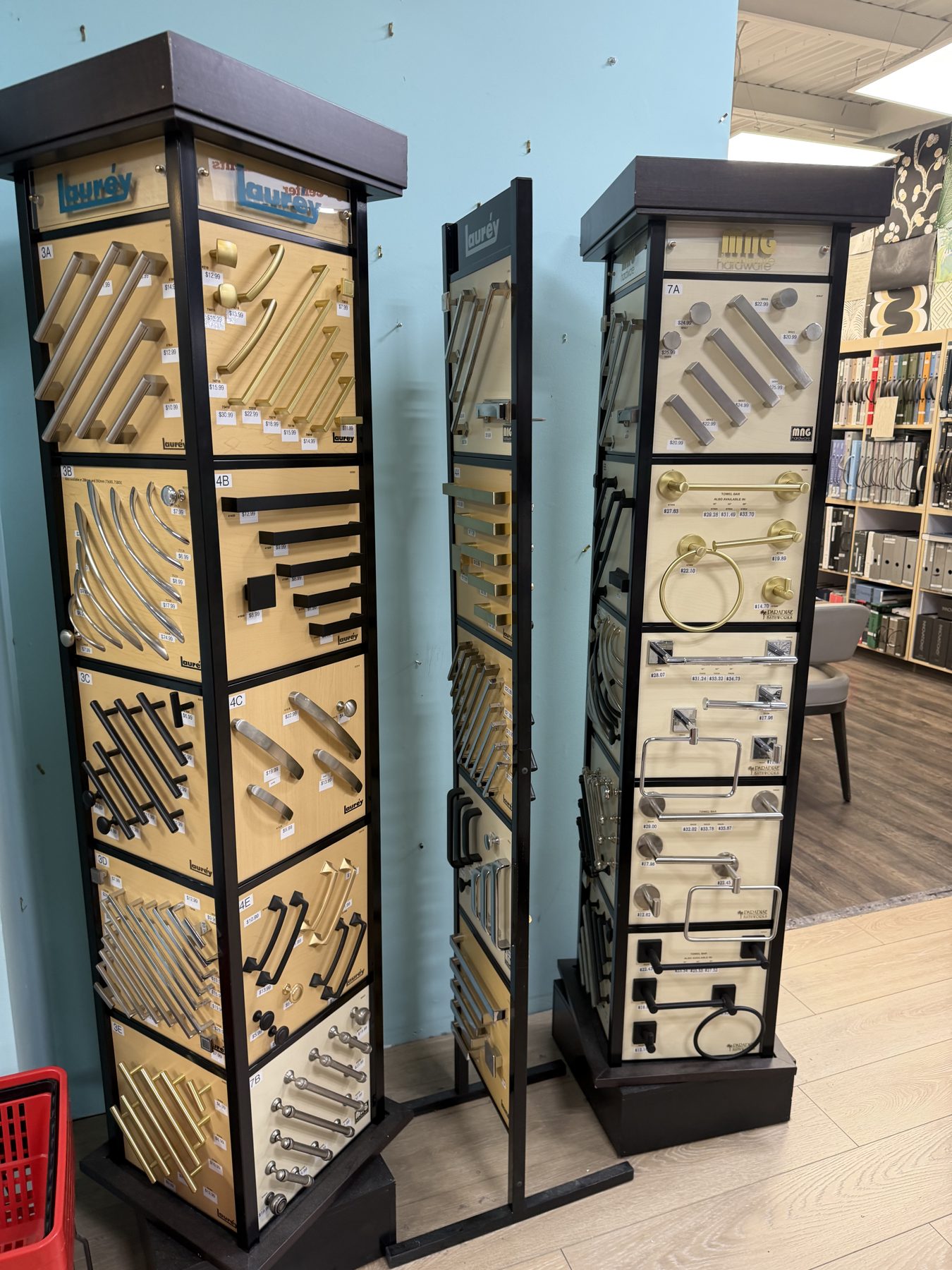 Rotating displays showcasing Laurey cabinet handles, modern drawer pulls, knobs, and bath hardware fixtures at Hessler Paint & Hardware in Delray Beach, Florida.
