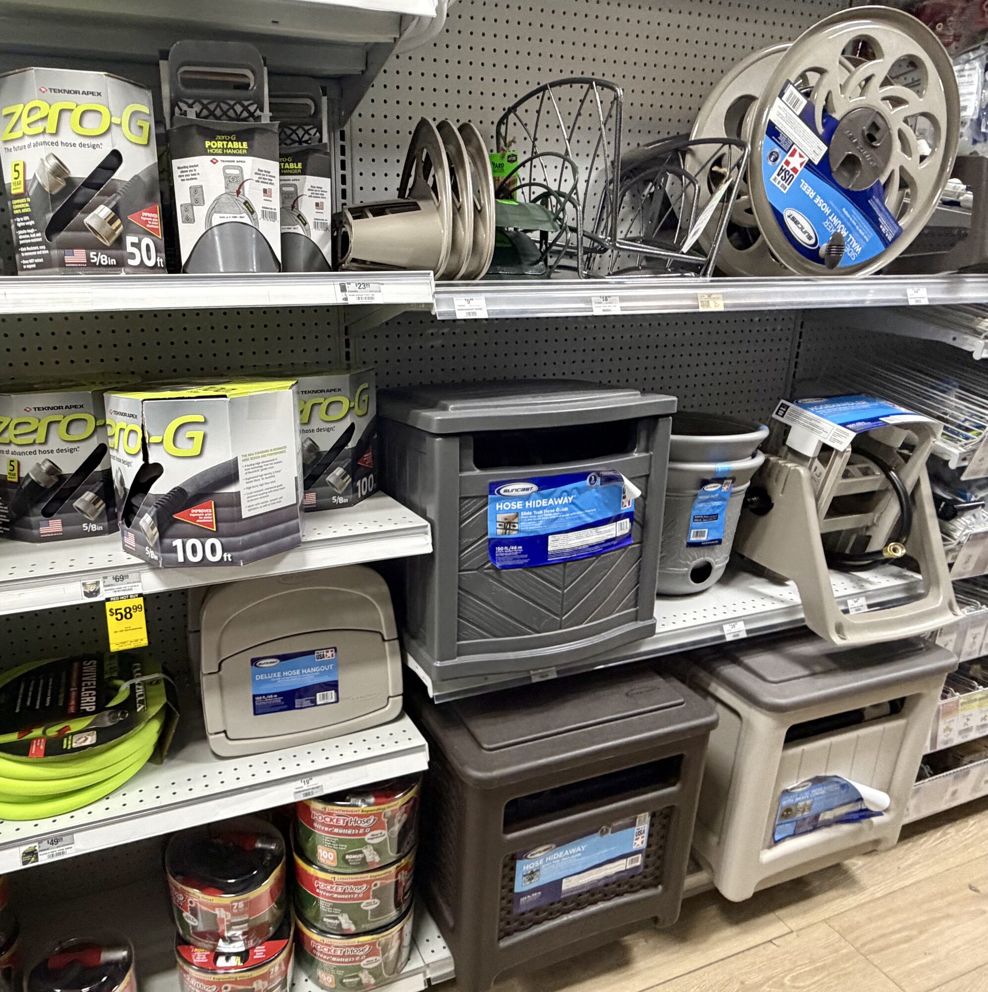 A display of Teknor Apex zero-G hoses, Suncast hose reels, and Hose Hideaway storage boxes at Hessler Paint & Hardware in Delray Beach, Florida.