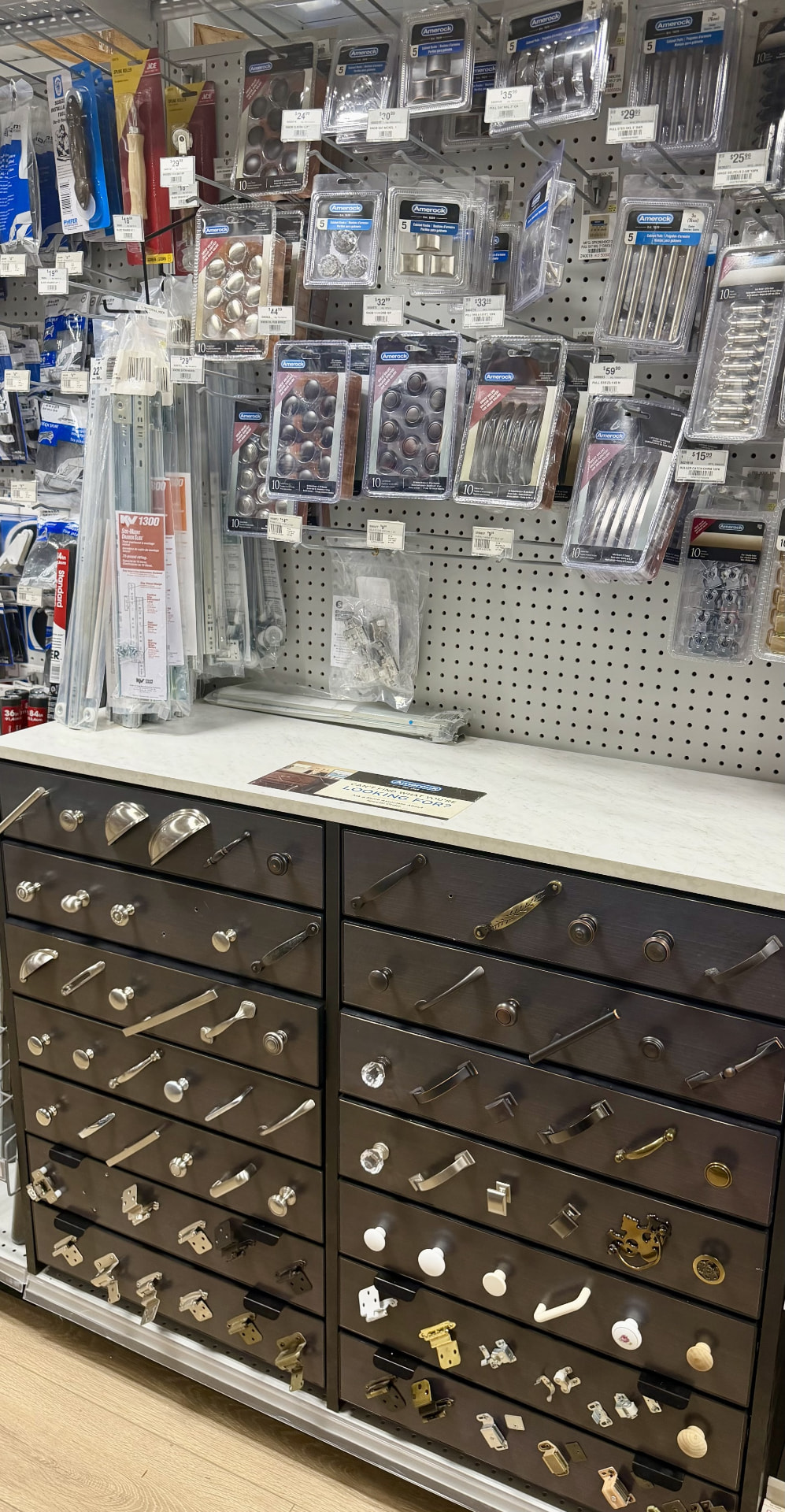 Amerock cabinet knobs and pulls display with drawer slides and hinges