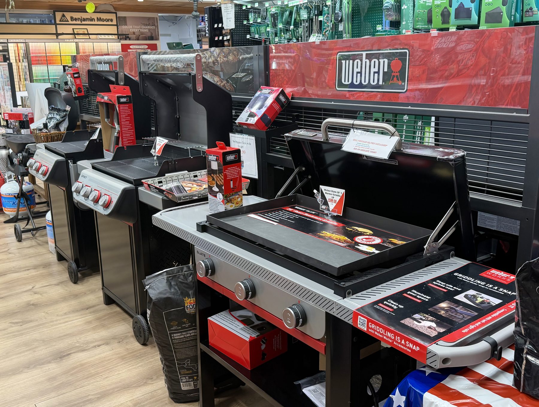 Display of Weber gas grills, Weber Slate griddles, and grilling accessories at Hessler Paint & Hardware in Delray Beach, Florida.