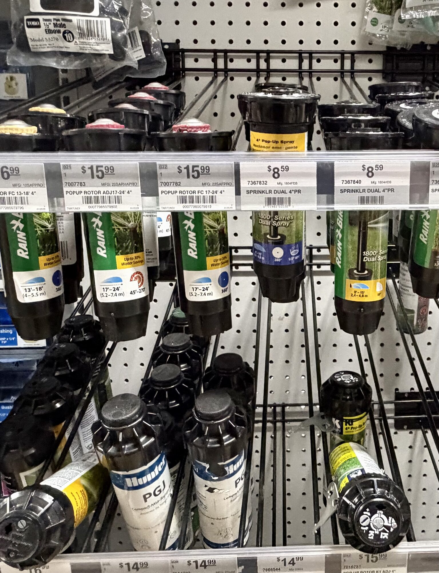 Rain Bird pop-up rotors, Hunter PGJ sprinklers, and Toro elbow fittings on display at Hessler Paint & Hardware in Delray Beach, Florida.