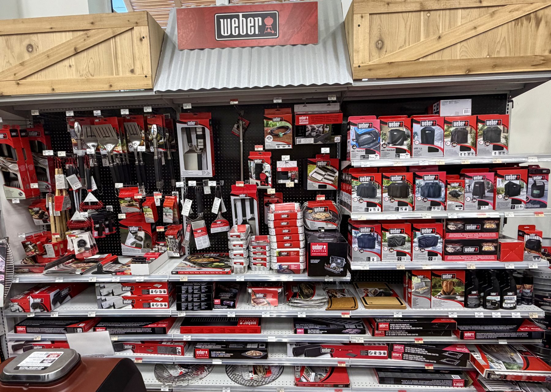 Display wall of Weber grill accessories, spatulas, tongs, grill covers, aluminum drip pans, and cleaning supplies at Hessler Paint & Hardware in Delray Beach, Florida.