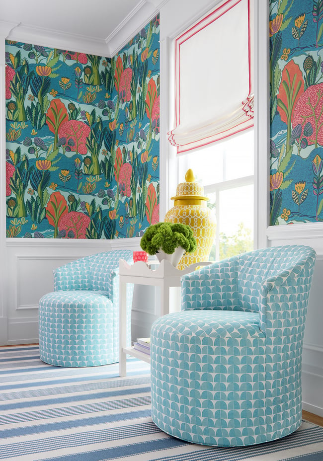 Sitting corner with bold botanical wallpaper, coordinating printed swivel chairs, and a striped rug