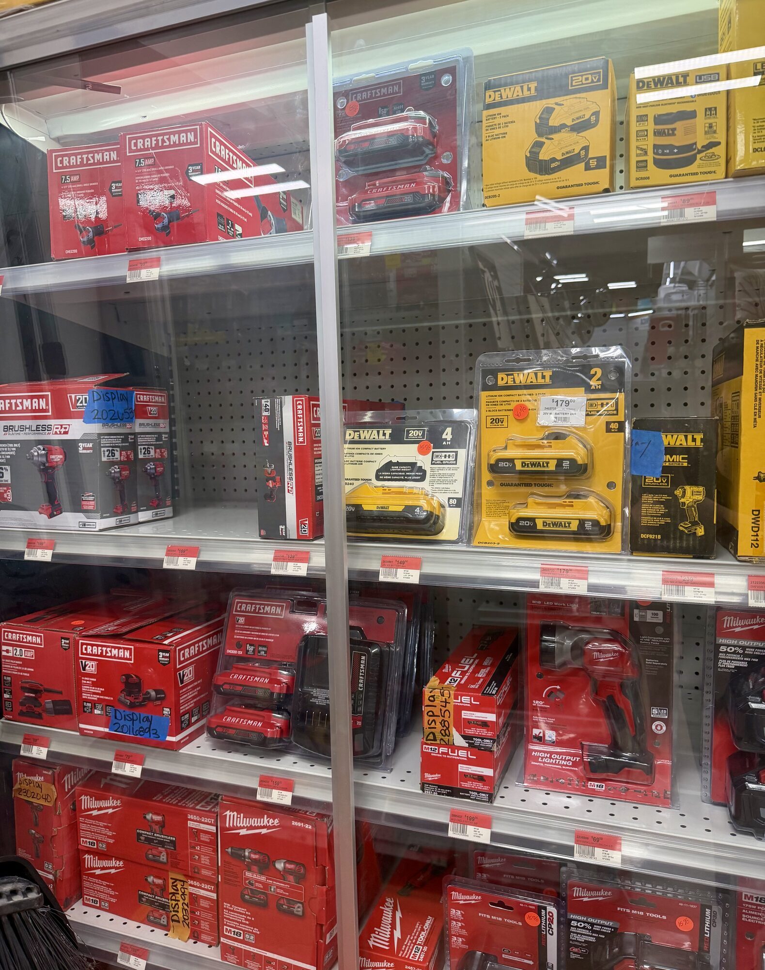 A display case featuring Craftsman, DeWalt, and Milwaukee power tools and battery packs at Hessler Paint & Hardware in Delray Beach, Florida.
