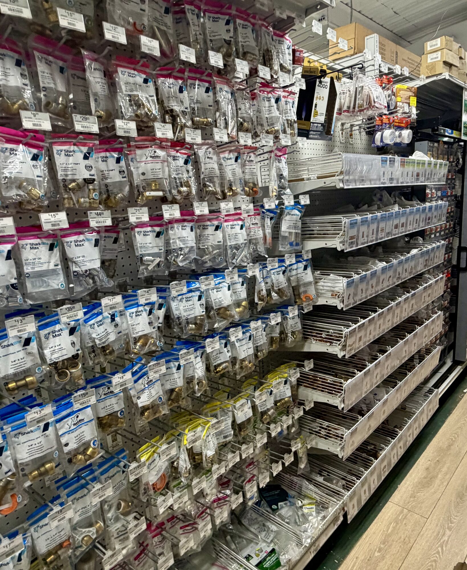 Shelves of SharkBite push-to-connect brass plumbing fittings and pipe connectors at Hessler Paint & Hardware in Delray Beach, Florida.