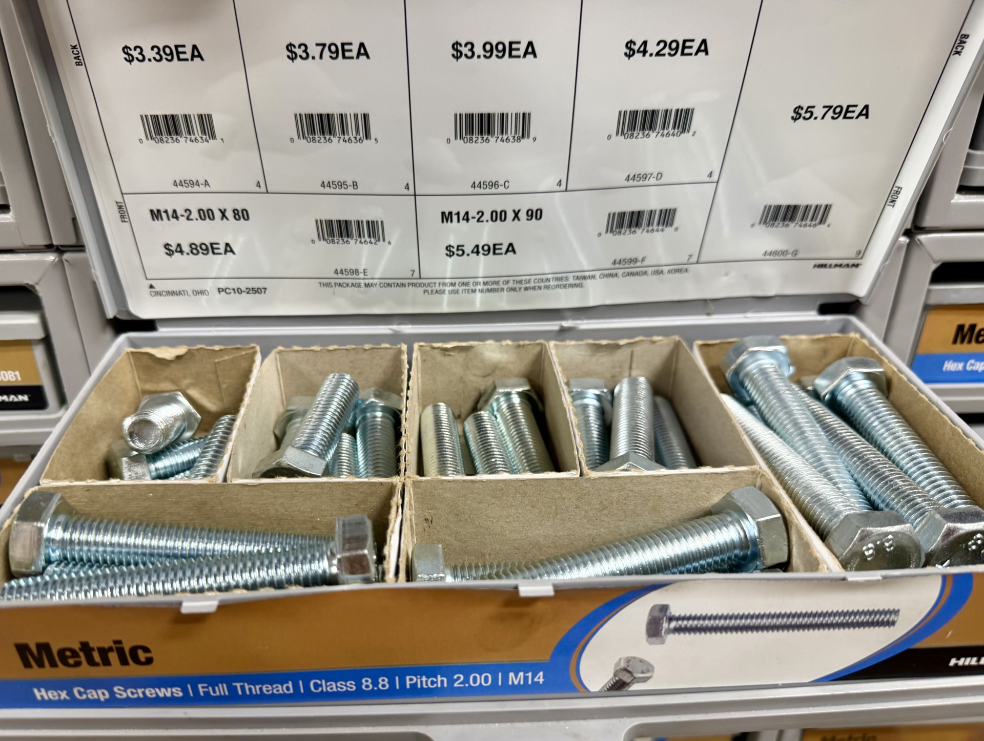 Metric Hillman hex cap screws in labeled bins with per-piece pricing