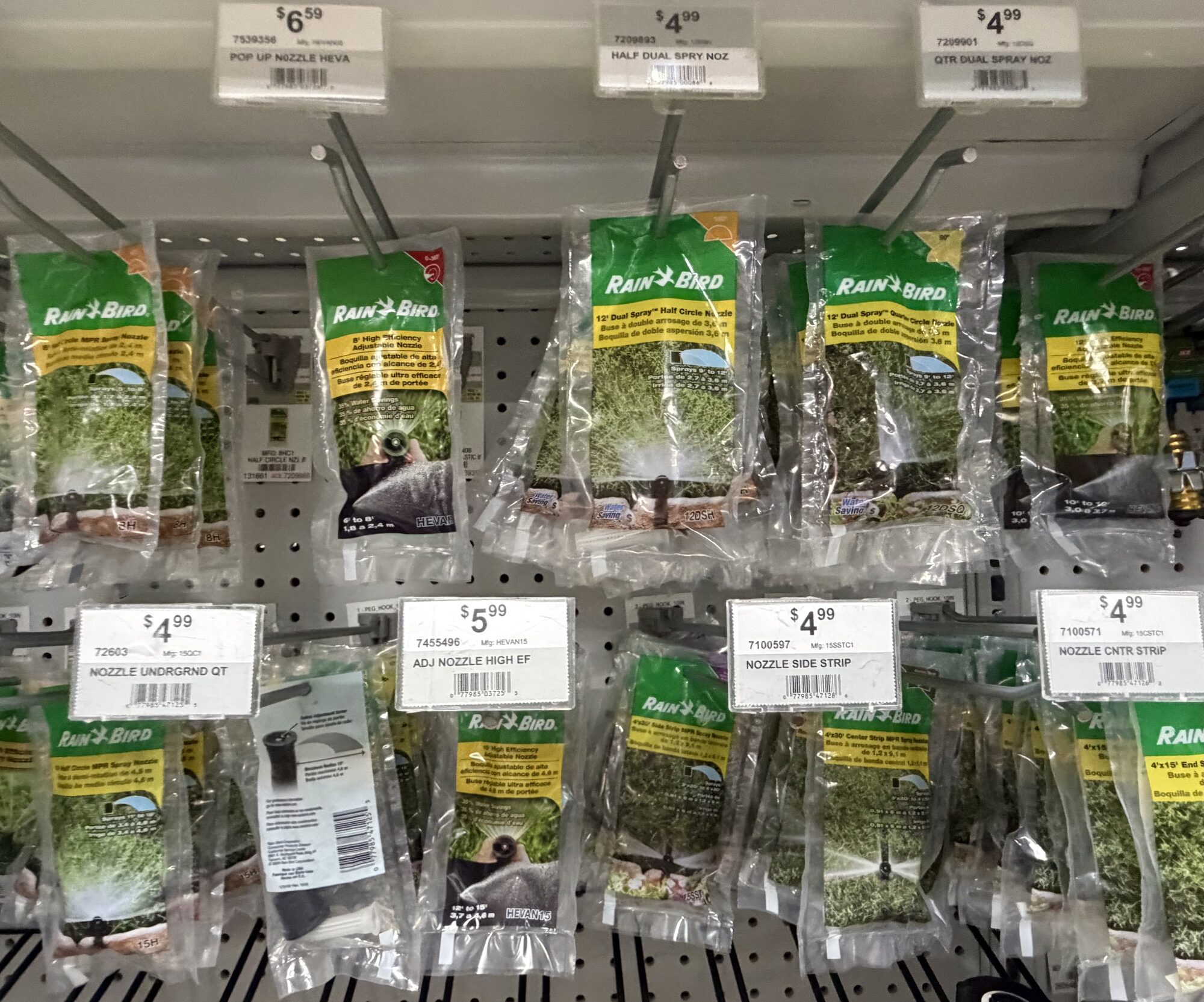 A display of Rain Bird irrigation nozzles including dual spray, pop-up, and high-efficiency models at Hessler Paint & Hardware in Delray Beach, Florida.