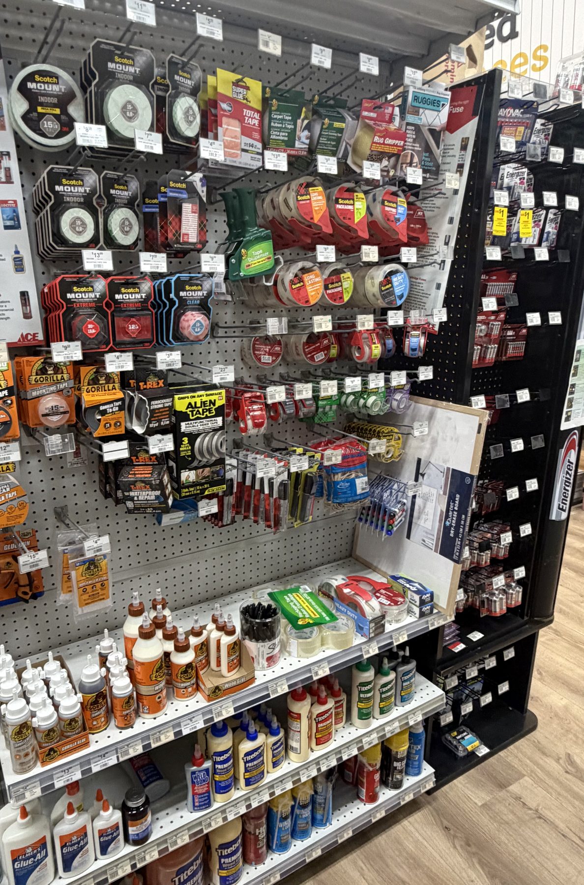 A hardware wall display stocked with Scotch Mount tape, Gorilla Tape, Alien Tape, T-Rex Tape, and various Titebond and Elmer's glues at Hessler Paint & Hardware in Delray Beach, Florida.