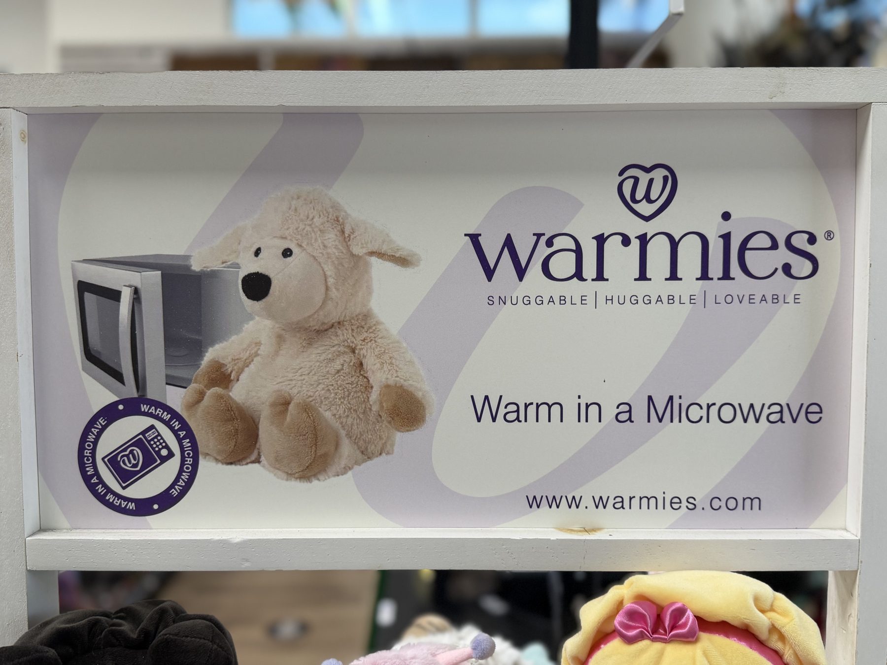 Warmies microwavable plush stuffed animal display sign at Hessler Paint & Hardware in Delray Beach, Florida.