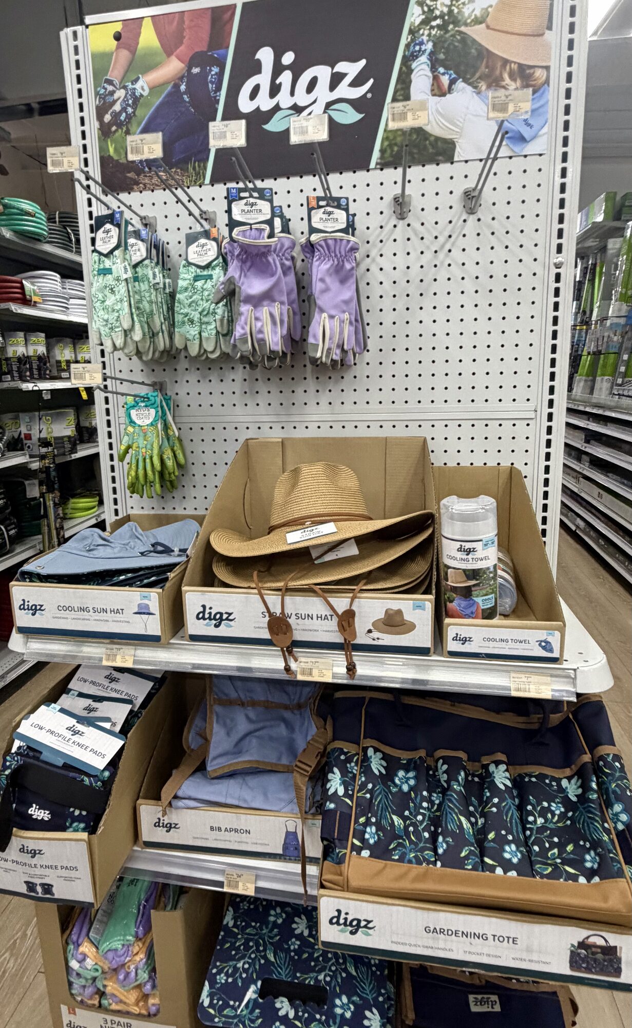 A display of Digz gardening accessories including gloves, straw sun hats, cooling towels, knee pads, and totes at Hessler Paint & Hardware in Delray Beach, Florida