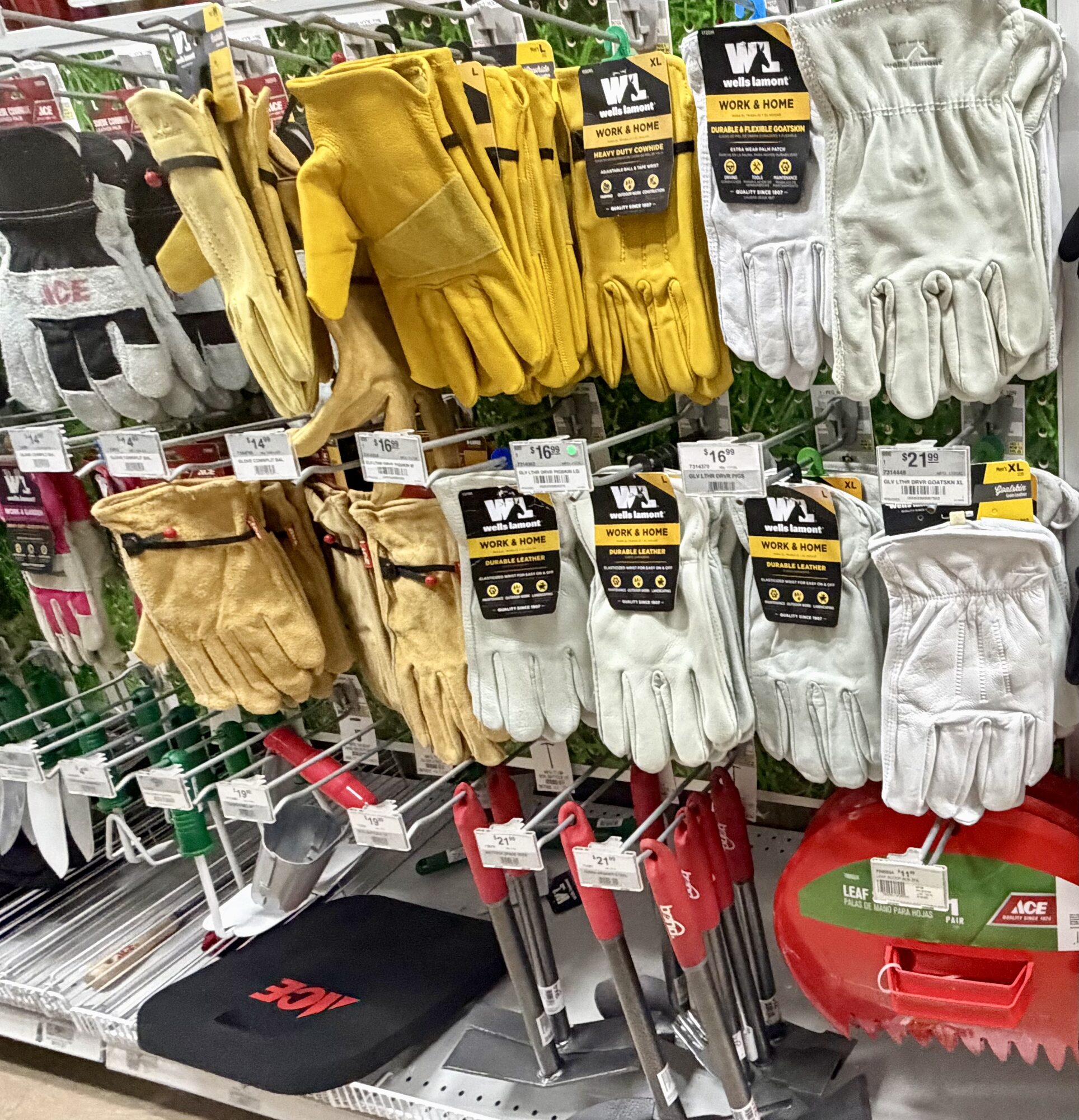 A display of Wells Lamont leather work gloves, Ace brand gardening tools, and kneeling pads at Hessler Paint & Hardware in Delray Beach, Florida.