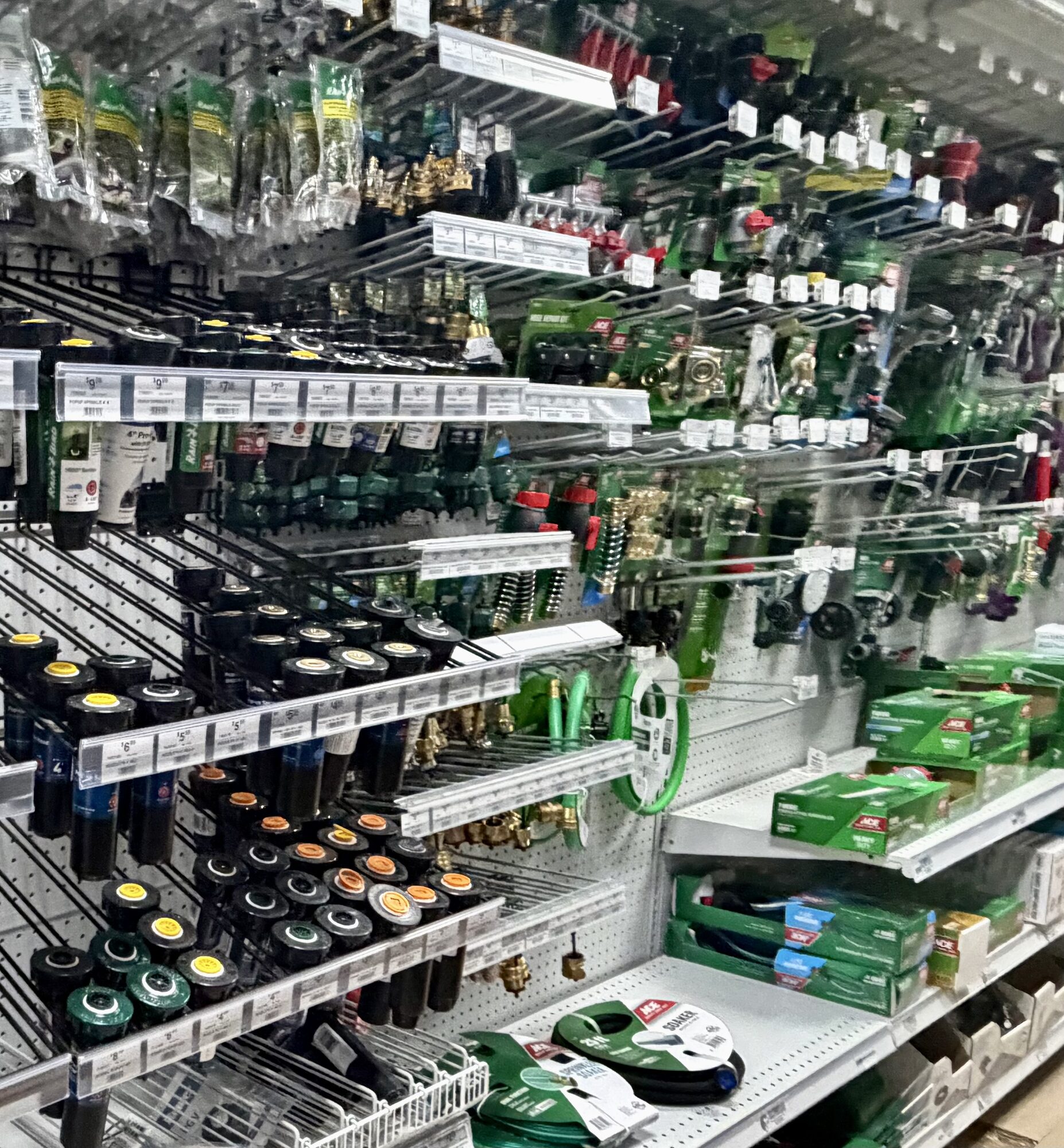 A wide selection of Rain Bird sprinkler heads, Ace garden hoses, and brass hose connectors at Hessler Paint & Hardware in Delray Beach, Florida.