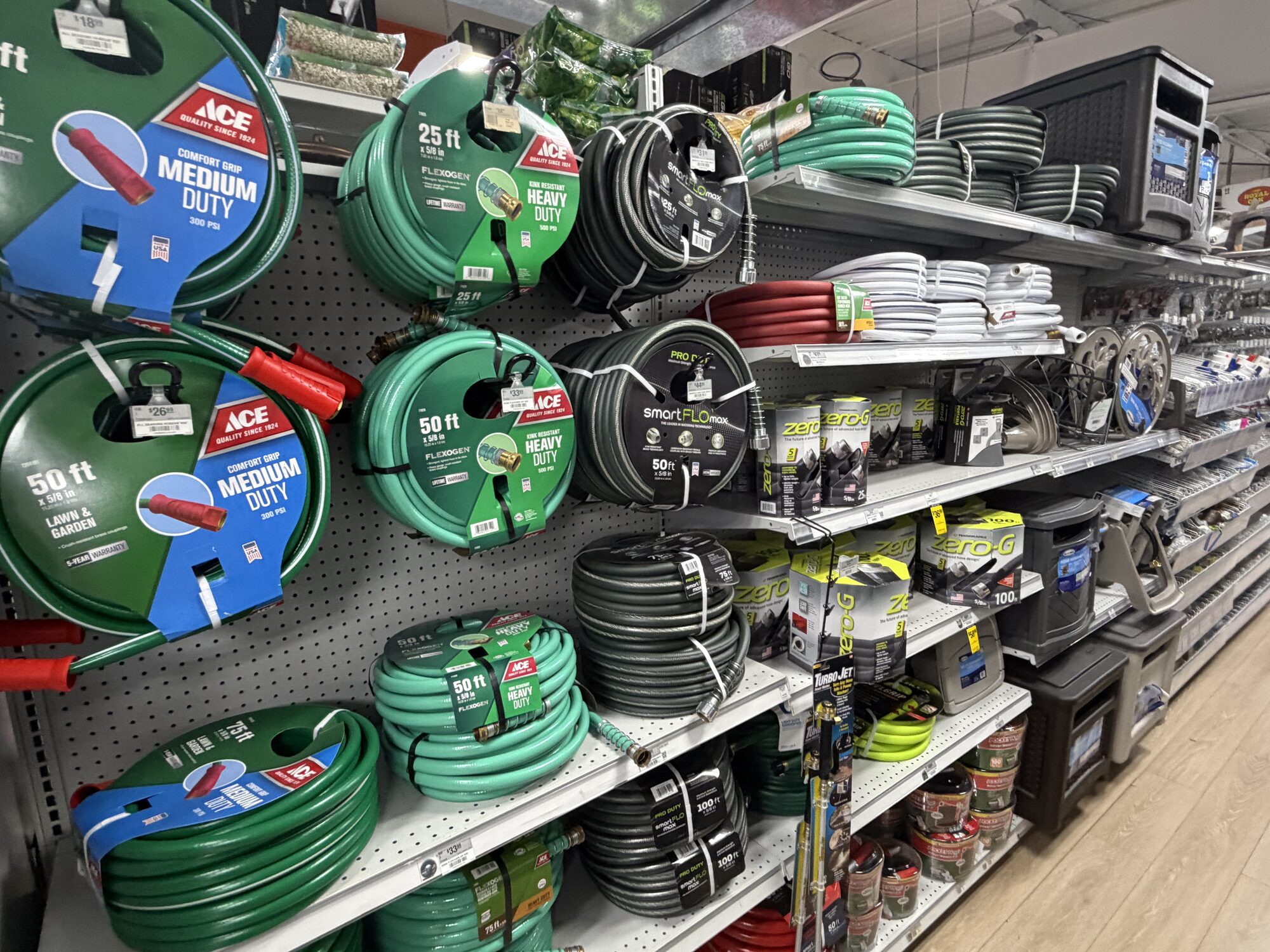 A variety of Ace Hardware and Zero-G garden hoses, hose reels, and watering accessories on display at Hessler Paint & Hardware in Delray Beach, Florida.