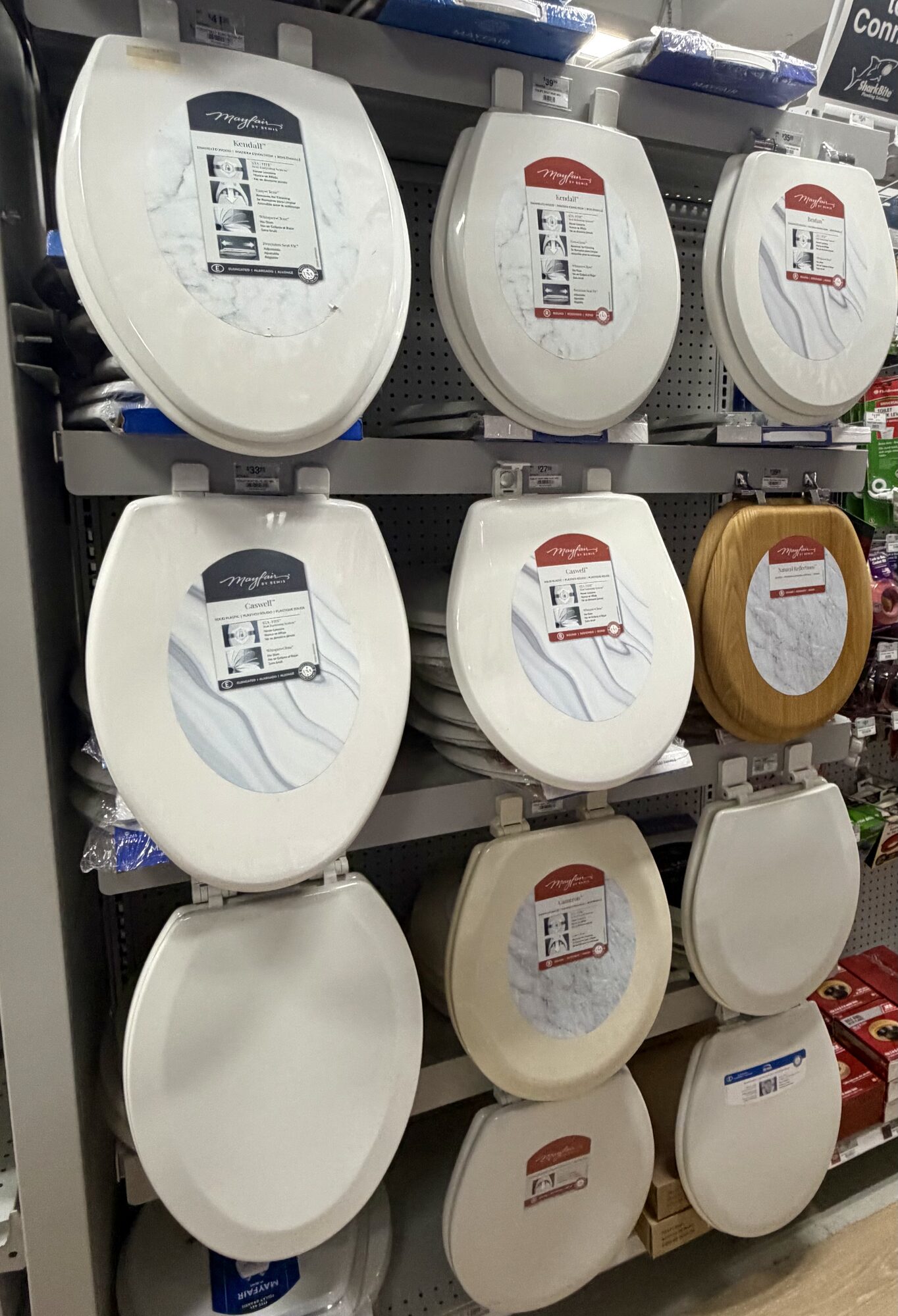 A display of Mayfair by Bemis toilet seats in various finishes and materials at Hessler Paint & Hardware in Delray Beach, Florida.