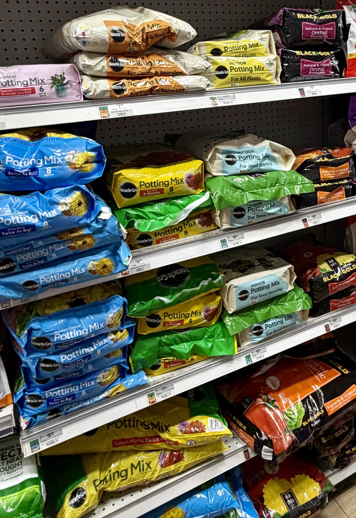 Shelves stocked with Miracle-Gro Potting Mix, Black Gold Orchid Mix, and Miracle-Gro Indoor Potting Mix at Hessler Paint & Hardware in Delray Beach, Florida.