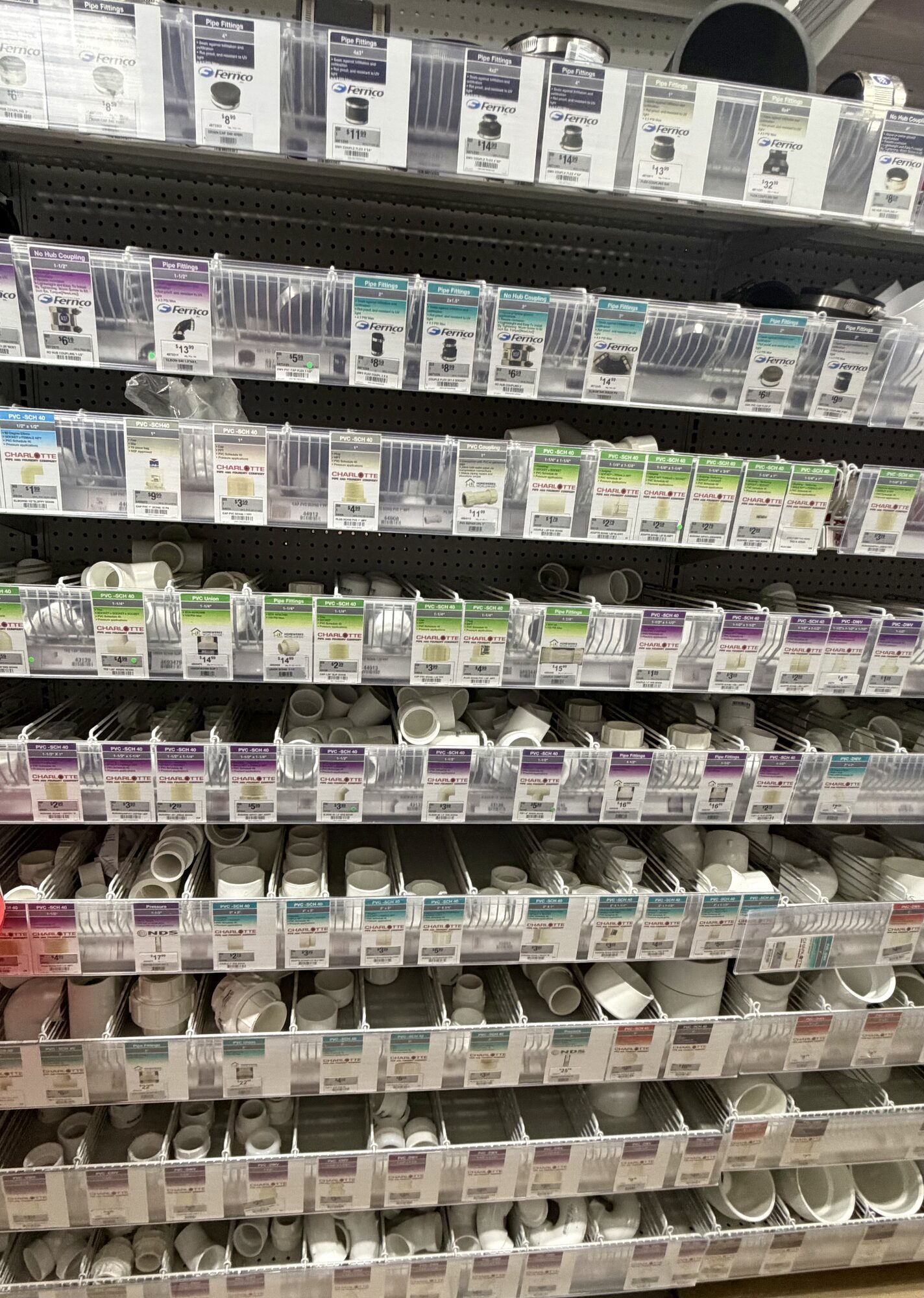 Shelves of Fernco pipe fittings and Charlotte Pipe PVC connectors, elbows, and couplings at Hessler Paint & Hardware in Delray Beach, Florida.