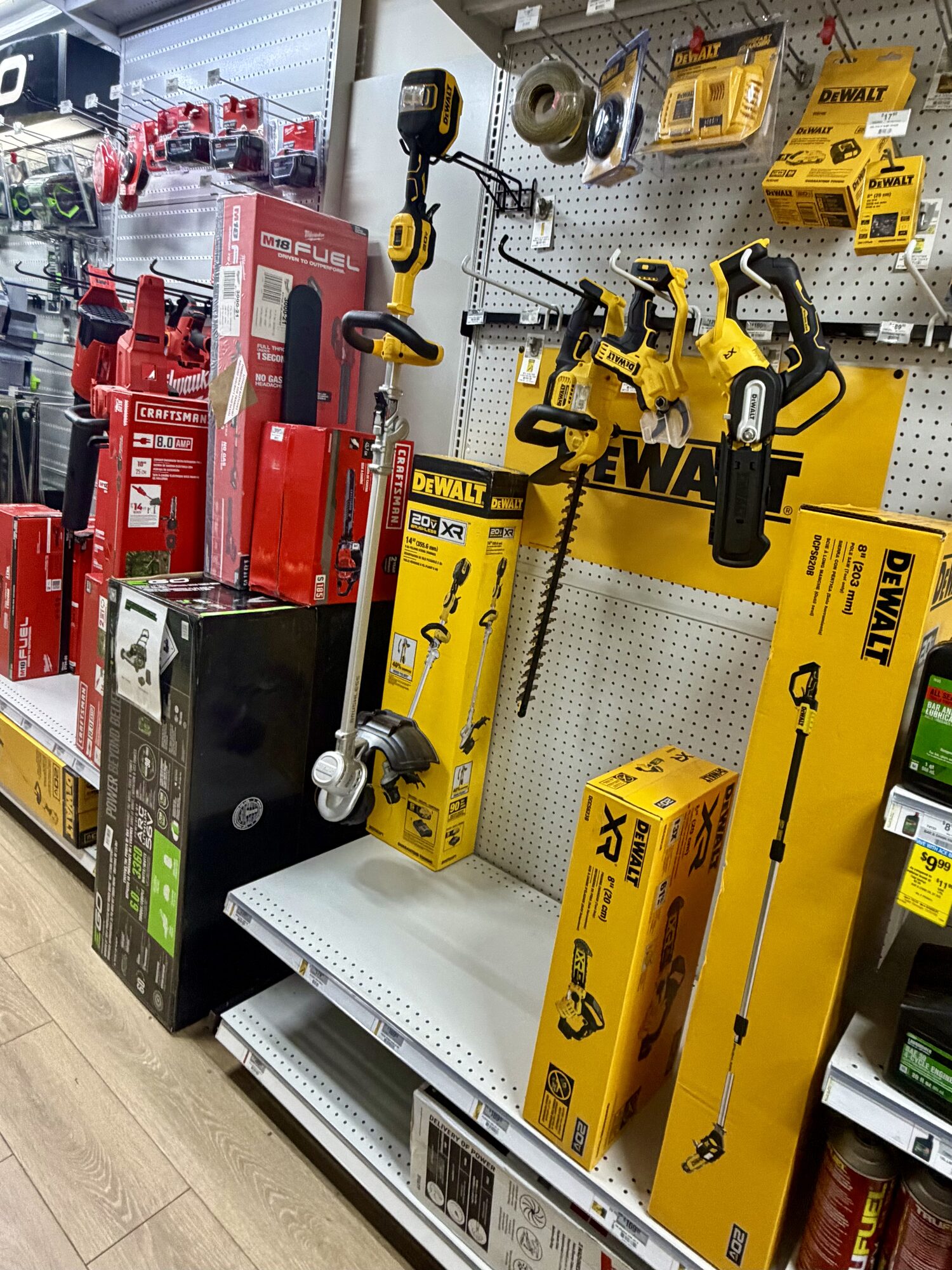 DeWalt and Milwaukee power tools including string trimmers, hedge trimmers, and chainsaws at Hessler Paint & Hardware in Delray Beach, Florida.