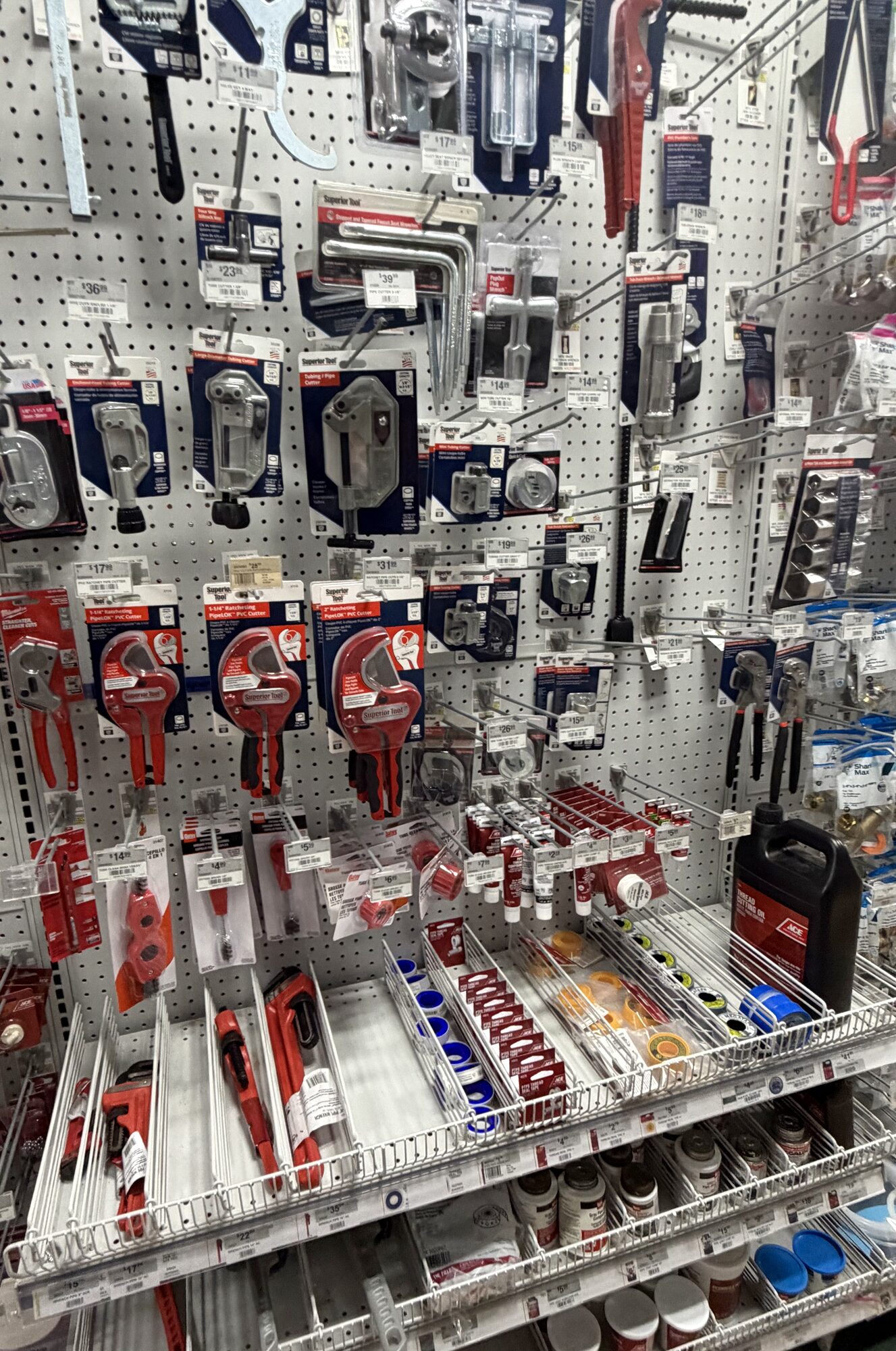 Display of plumbing hand tools including Superior Tool pipe cutters, basin wrenches, and pipe sealants at Hessler Paint & Hardware in Delray Beach, Florida.