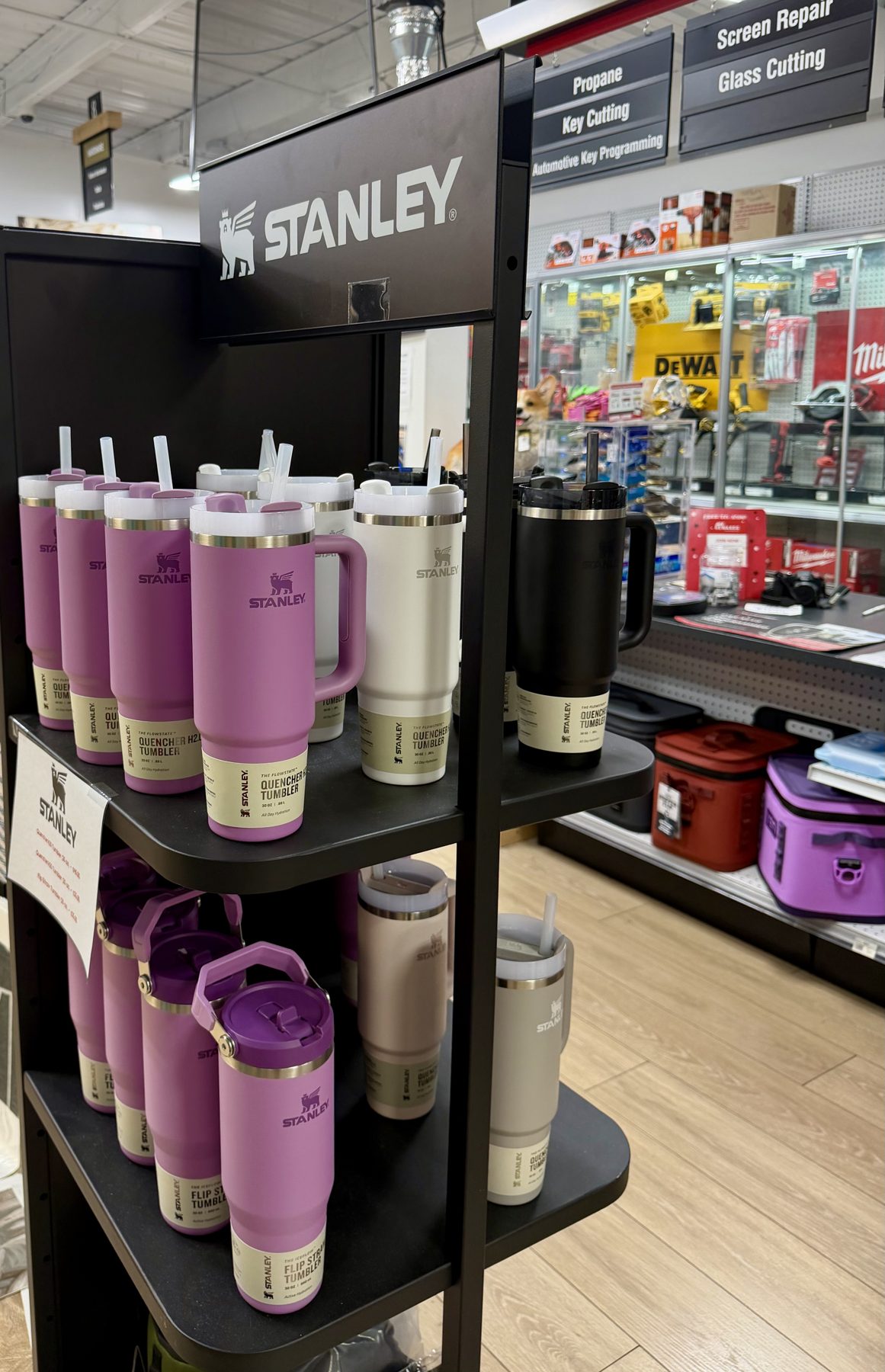 A Stanley display rack filled with purple, cream, and black Stanley Quencher H2.0 FlowState tumblers and straw bottles at Hessler Paint & Hardware in Delray Beach, Florida.