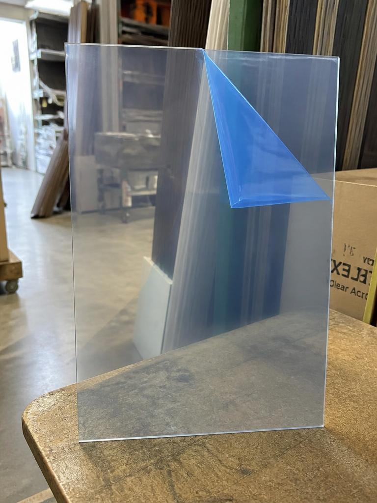 Sheet of clear acrylic plexiglass cut to size with protective film peeled back at one corner